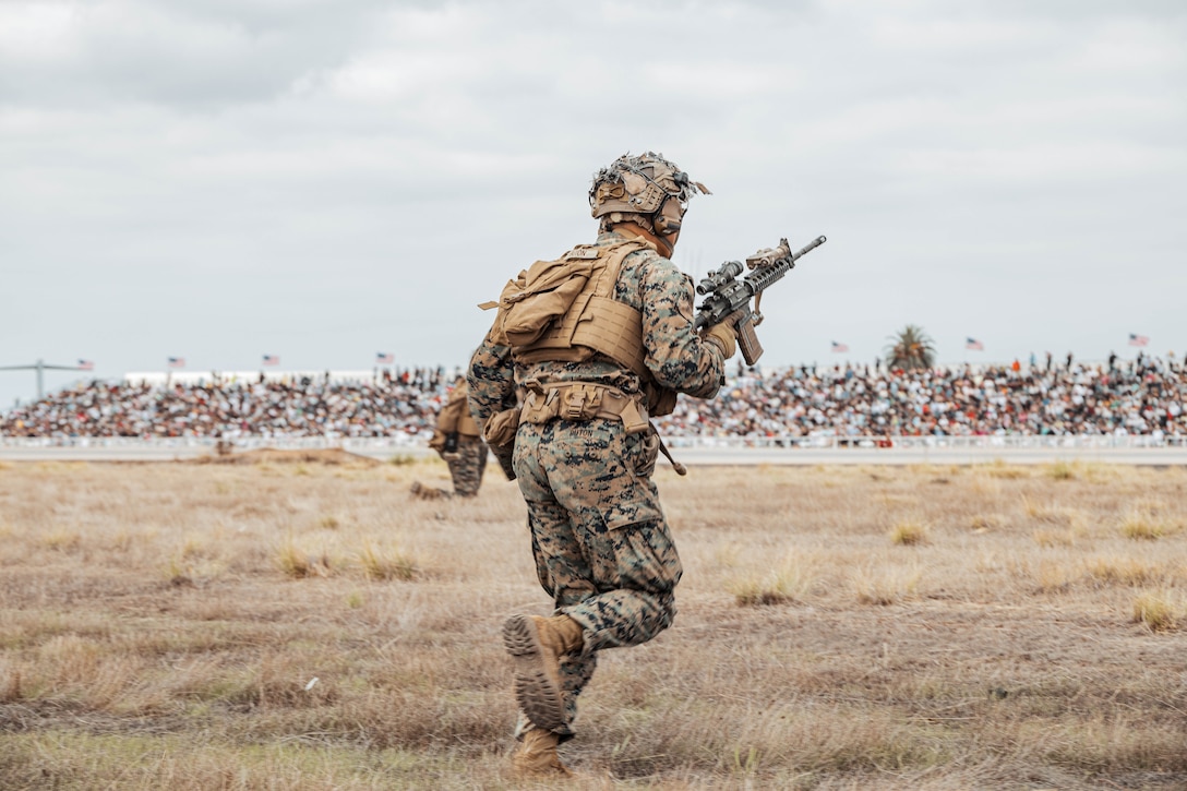U.S. Marine Corps Lance Cpl. Jasper Buton with 2nd Battalion, 4th Marine Regiment, 1st Marine Division, rushes during a fire and maneuver movement during the Marine Air-Ground Task Force demonstration during the 2025 Marine Corps Air Station Miramar Air Show in San Diego, Sept. 27, 2025. The MAGTF Demo displays the coordinated use of close-air support, armor, artillery and infantry forces and provides a visual representation of how the Marine Corps operates. America's Air Show 2025 is a unique and incredible opportunity to witness Marine and joint aviation capabilities, civilian performers and the world-famous Blue Angels; to celebrate the 250th birthday of the Marine Corps alongside Marines and to see first-hand the innovative spirit of the Marine Corps through emerging technologies and forward-thinking. (U.S. Marine Corps photo by Cpl. Sarah M. Grawcock)