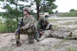 Sgt. Makayla Gassett provides security while Staff Sgt. Michael Wright, both with the 445th Medical Detachment (Veterinary Services), renders medical aid to a simulated casualty during the situational training exercise (STX) lanes in July’s WAREX 25 at Joint Base McGuire-Dix-Lakehurst. WAREX, a two-week field exercise, focuses on sharpening basic soldiering skills and unit tactical movement in austere conditions. (U.S. Army Reserve photo by Lt. Col Kristin Porter)
