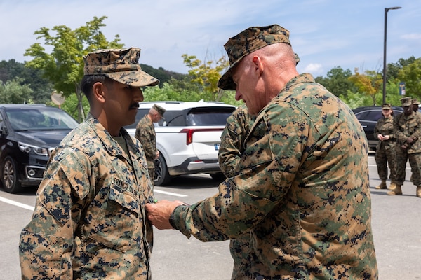 U.S. Navy Petty Officer 2nd Class Daniel Franco Colon, left, a hospital corpsman with 2nd Battalion, 23rd Marine Regiment, forward deployed with 4th Marines, 3rd Marine Division as part of the Unit Deployment Program, stands at attention while Lt. Gen. Roger Turner, commanding general of III Marine Expeditionary Force, presents him with the Navy and Marine Corps Achievement Medal during Korean Marine Exercise Program 25.2 in Camp Mujuk, South Korea, Aug. 7, 2025. KMEP is conducted regularly between the Republic of Korea and U.S. Marine Corps to increase their combined capabilities through realistic training geared towards deterrence and maintaining peace in the Indo-Pacific. Franco Colon is a native of Florida, and Turner is a native of Maryland. (U.S. Marine Corps photo by Cpl. Peter J. Eilen)