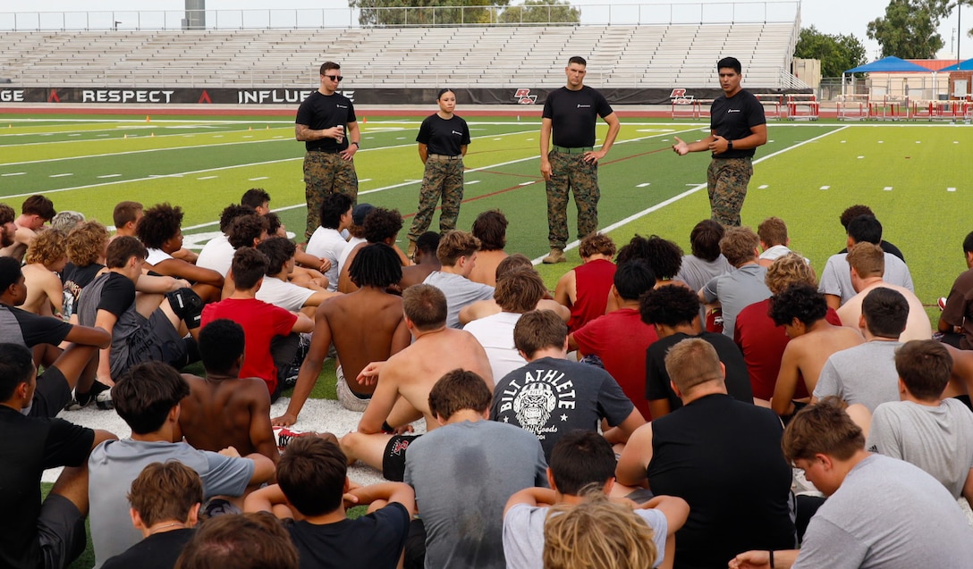 Marines with Recruiting Sub-Station Mesa, Recruiting Station Phoenix, answer Red Mountain High School football players' questions during a Glazier clinics combat fitness test event at Red Mountain High School, Mesa, Ariz., July 16, 2025. Glazier helps set up events nationwide , engaging high school football teams in exclusive training opportunities alongside Marines fostering camaraderie and team cohesion. ( U.S. Marine Corps photo by Sgt. Similar Bostic)
