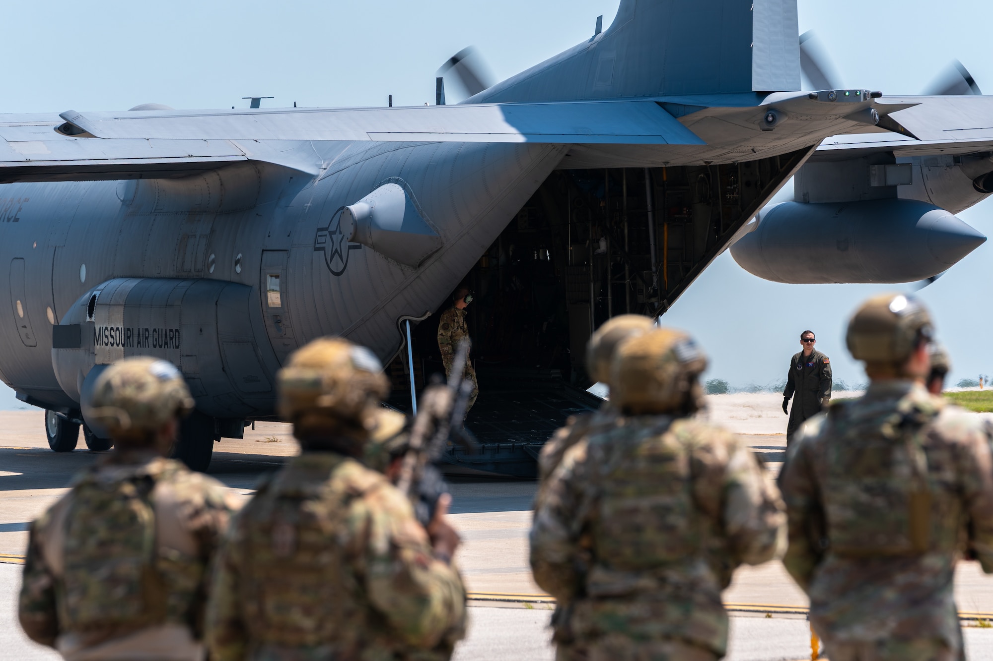 U.S. Airmen assigned to the 509th Security Forces Squadron run toward a C-130 Hercules aircraft from Rosecrans Air National Guard Base, Missouri, at Whiteman Air Force Base, Missouri, Aug. 8, 2025. The Airmen participated in a high-value individual transfer exercise where they had to escort a subject on an aircraft and to a destination in a simulated contested area. (U.S. Air Force photo by Staff Sgt. Joshua Hastings)