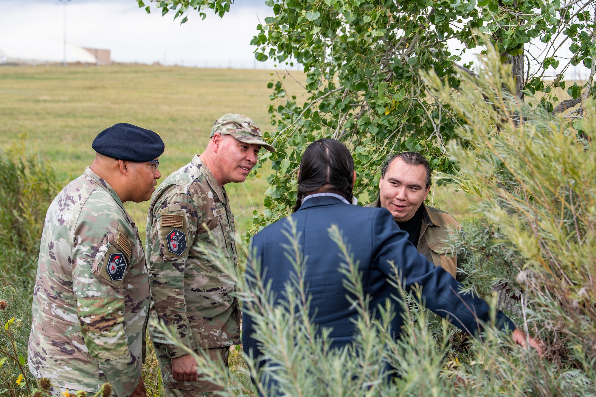 Col. David Berrios and Chief Master Sgt. Gerald Morey listen as Tyrel Iron Eyes explains the cultural significance of plants and their uses during the Department of the Air Force Front Range Tribal Consultation.