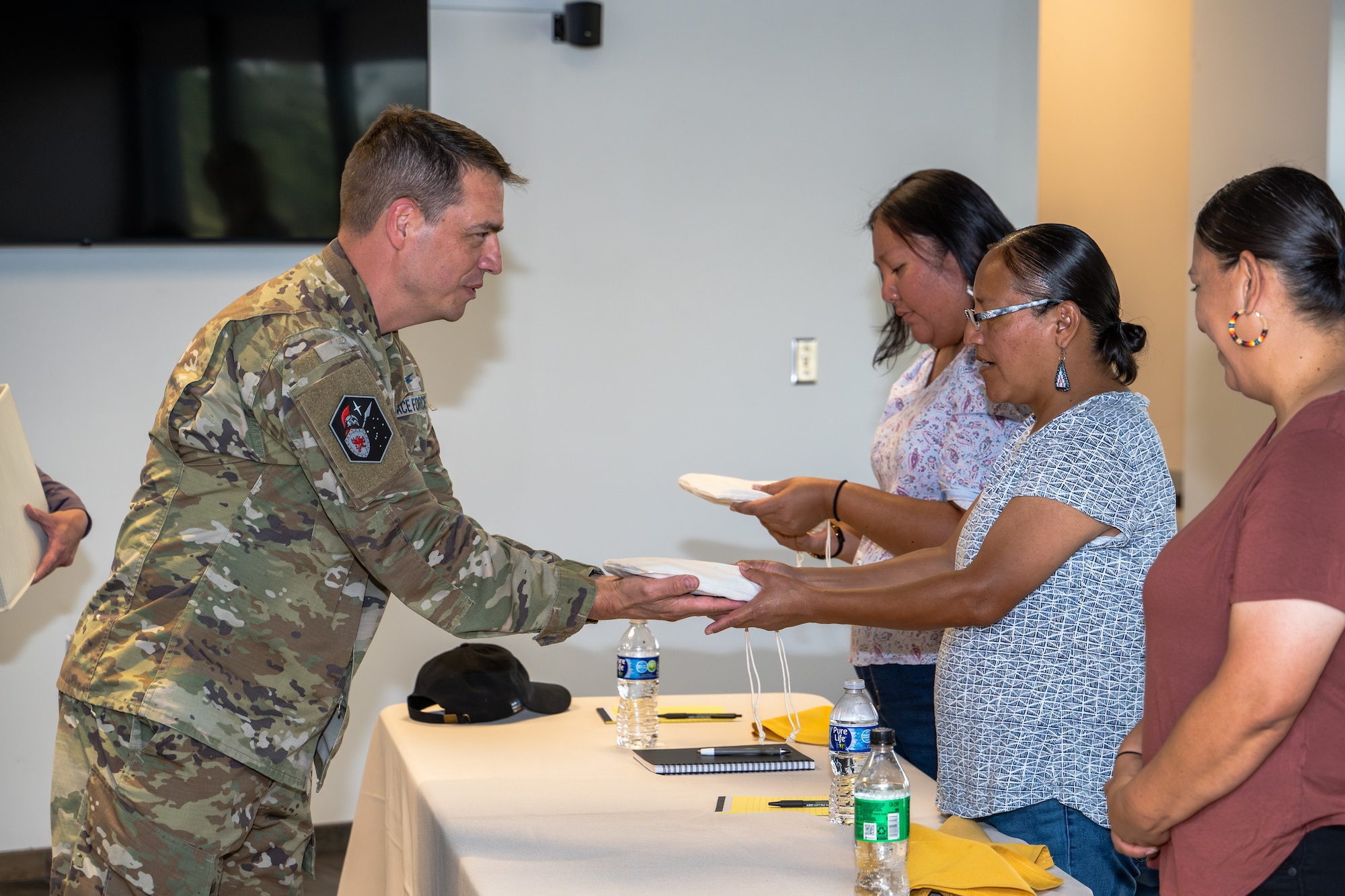 Col. Eric Bogue hands a gift to Alvonia McElroy.