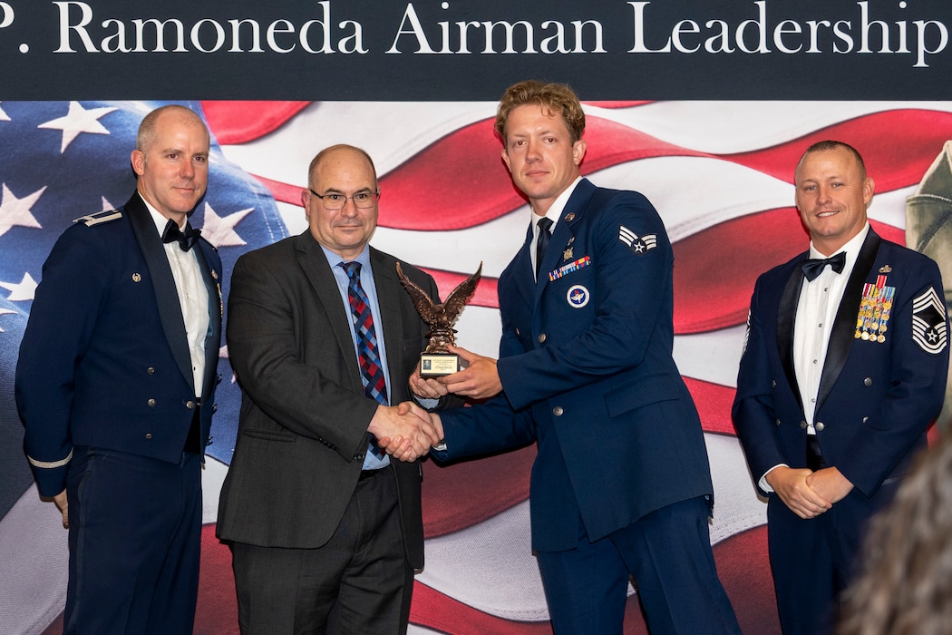 John Levitow, Jr. stands with the award winner at a graduation at Travis AFB.