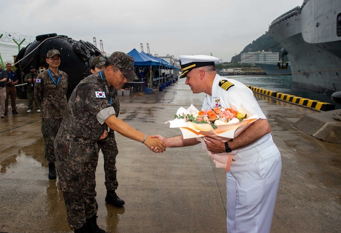 Capt. Louis F. Catalina, commanding officer of U.S. 7th Fleet flagship USS Blue Ridge (LCC 19) greets  Republic of Korea Navy Capt. Shim Mu-sik, commodore, Force Protection Squadron, on the pier upon arriving in Busan, South Korea, Sept. 25, 2025.