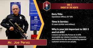 A police officer poses with an unloaded rifle as he is recognized as Space Base Delta 3 October 2025 Knight of the Month