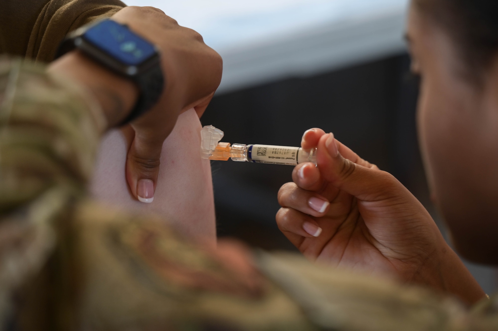 A syringe being inserted into an arm.
