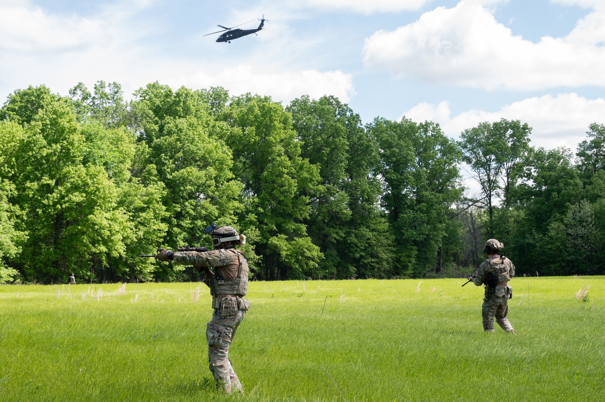 U.S. Air Force Staff Sgt. Kevin Parker, 509th Security Forces Squadron Base Response Team noncommissioned officer in charge, left, and Airman 1st Class Daniel Riesgo, 509th SFS Base Response Team member, survey the surrounding area during a joint force exercise in Clinton, Missouri, May 4, 2025. The 509th SFS Base Response Team collaborated with the Missouri Army National Guard 1-135 Assault Helicopter Battalion for an exercise that prepared the defenders to seek out and secure high-value targets. (U.S. Air Force photo by Senior Airman Joseph Garcia)