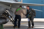 A F-16 Fighting Falcon aircraft pilot assigned to the Slovak Armed Forces shakes hands with a U.S. Air Force crew chief after a joint training flight at Morris Air National Guard Base, Tucson, Arizona, Feb. 15, 2026. The handshake marks the teamwork and coordination required during Department of War National Guard Bureau State Partnership Program missions, where U.S. and Slovak pilots conduct coordinated combat training flights to strengthen readiness and independent airpower capabilities. Photo by Airman 1st Class Danielle Hough.