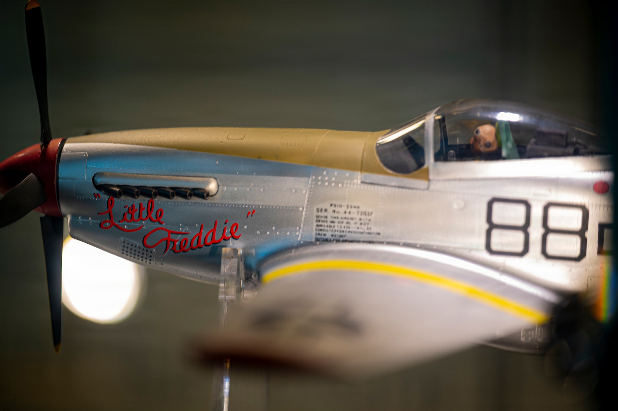 A model of P-51 Mustang “Little Freddie” sits static at new Tuskegee Airmen exhibit at the Virginia Air and Space Science Center in Hampton, Virginia, March 26, 2026. The P-51 Mustang was a WWII-era fighter operated by the Tuskegee Airmen that saw combat in the Pacific and European theaters. The iconic red paint on the tail and aft flight control surfaces became a moniker for the Tuskegee Airmen, known also as the “Redtails”. (U.S. Air Force photo by Staff Sgt. Michael Bowman)