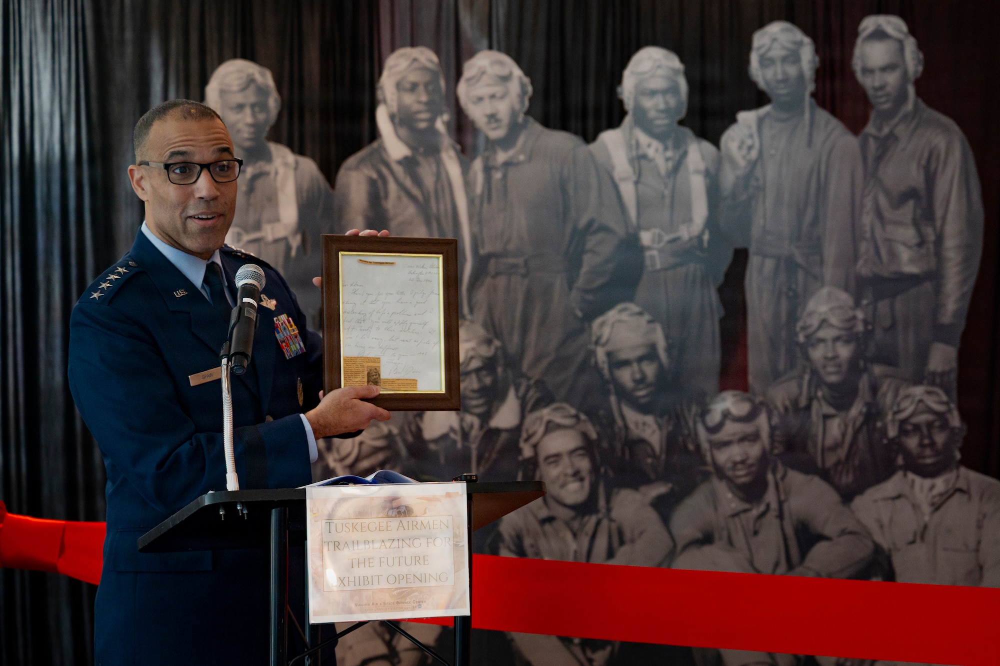 U.S. Air Force Gen. Adrian Spain, commander of Air Combat Command, gives remarks during the grand opening of the new Tuskegee Airmen exhibit at the Virginia Air and Space Science Center in Hampton, Virginia, March 26, 2026. As commander of ACC, Spain oversees the 332nd Air Expeditionary Wing, who continue to carry forth the legacy of the original 332d Fighter Group. (U.S. Air Force photo by Staff Sgt. Michael Bowman)