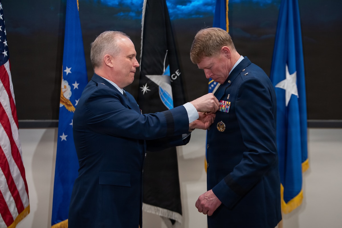 Brig. Gen. Jason Bartolomei, left, Air Force Research Laboratory (AFRL) commander, presents the Legion of Merit to Brig. Gen. (Dr.) Robert Bogart, right, outgoing commander of the 711th Human Performance Wing, during the Wing’s change of command ceremony at Wright-Patterson Air Force Base, Ohio, March 30, 2026.