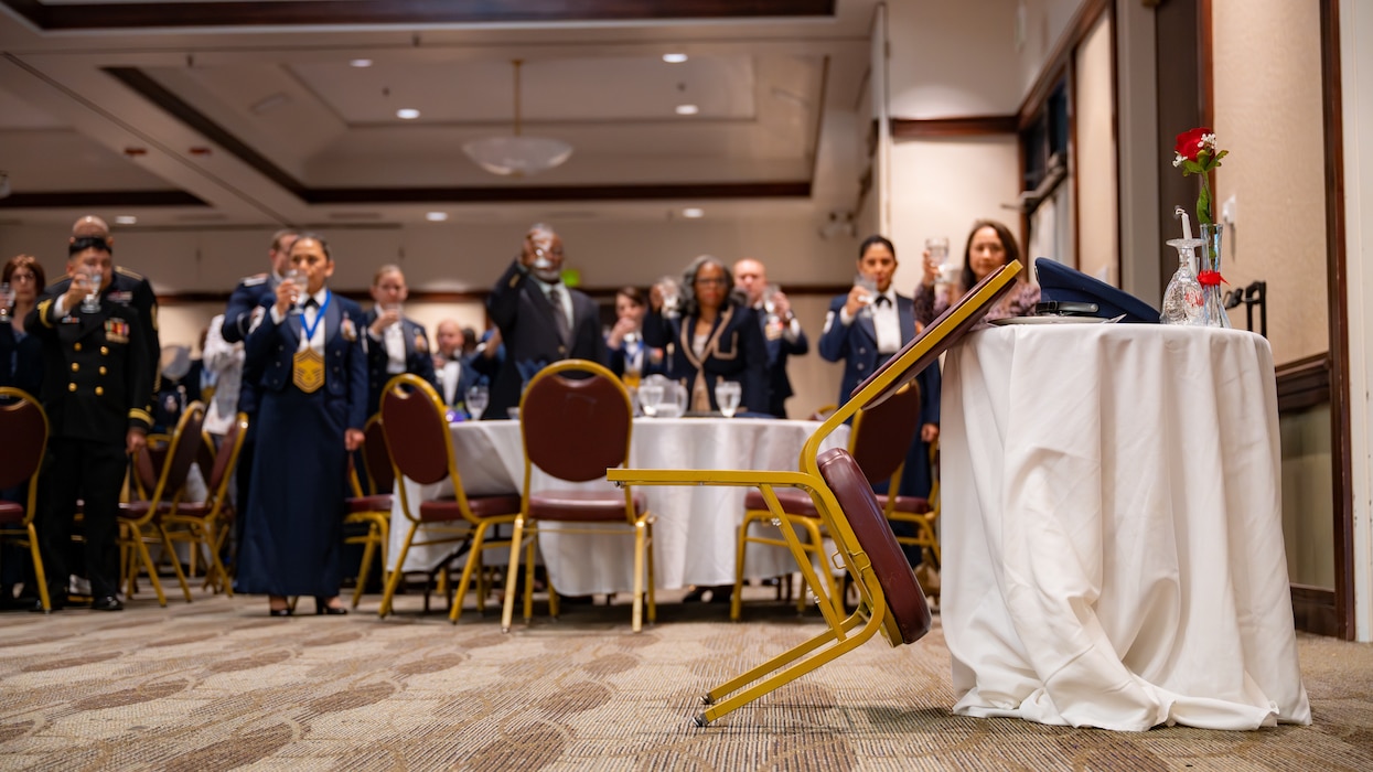 A chair is leaned against a table in focus with the toasters out of focus behind