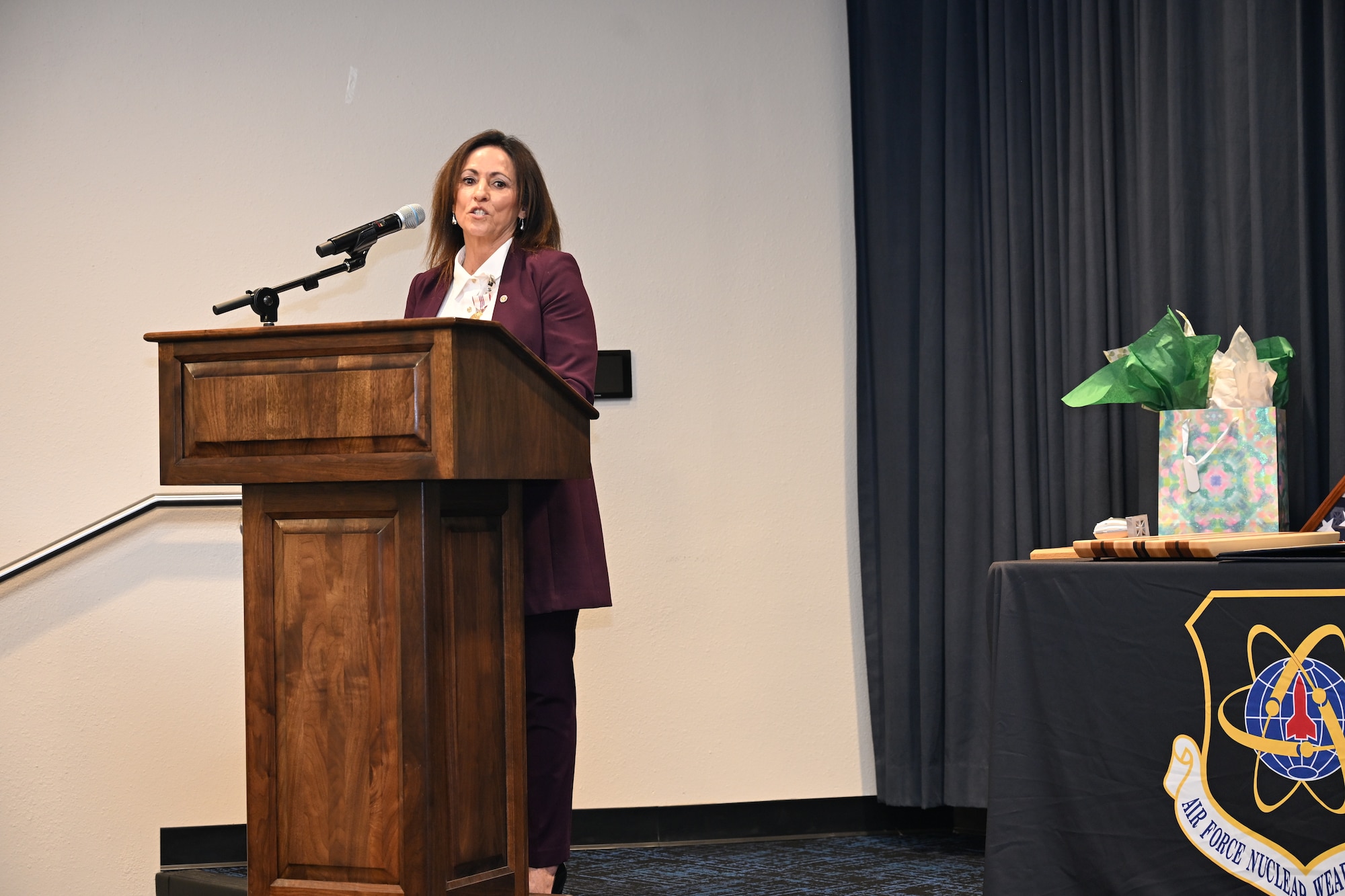 A woman in business attire speaks at a podium