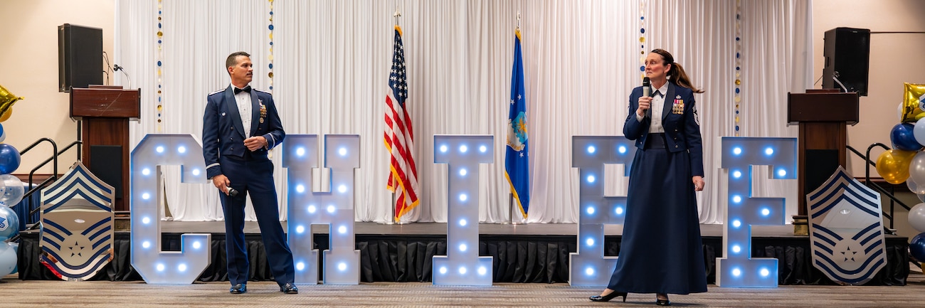 Air Force leadership speak while standing adjacent to each other in front of a lighted "CHIEF" sign