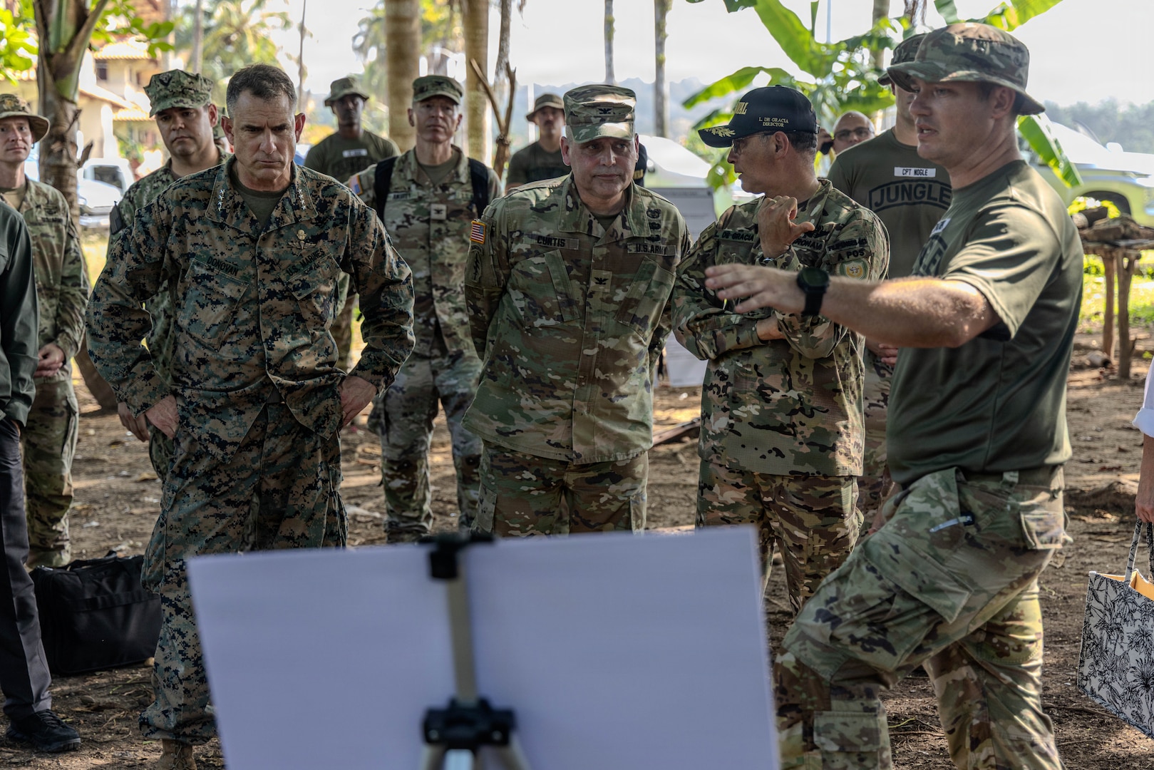 A group of men in military uniforms speak to each other.