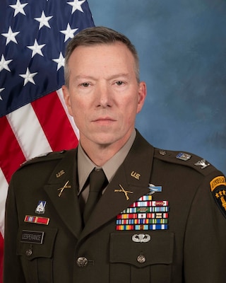 Headshot of Jeff Lesperance , USAWC staff, smiling against a neutral background and American Flag.