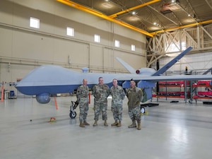 U.S. Air Force Chief Master Sgt. Timothey Hodgin, Air Force Research Laboratory command chief, and Airmen assigned to the 25th Aircraft Maintenance Squadron pose for a photo in front of an MQ-9 Reaper at Creech Air Force Base, Nevada, Jan. 9, 2026.