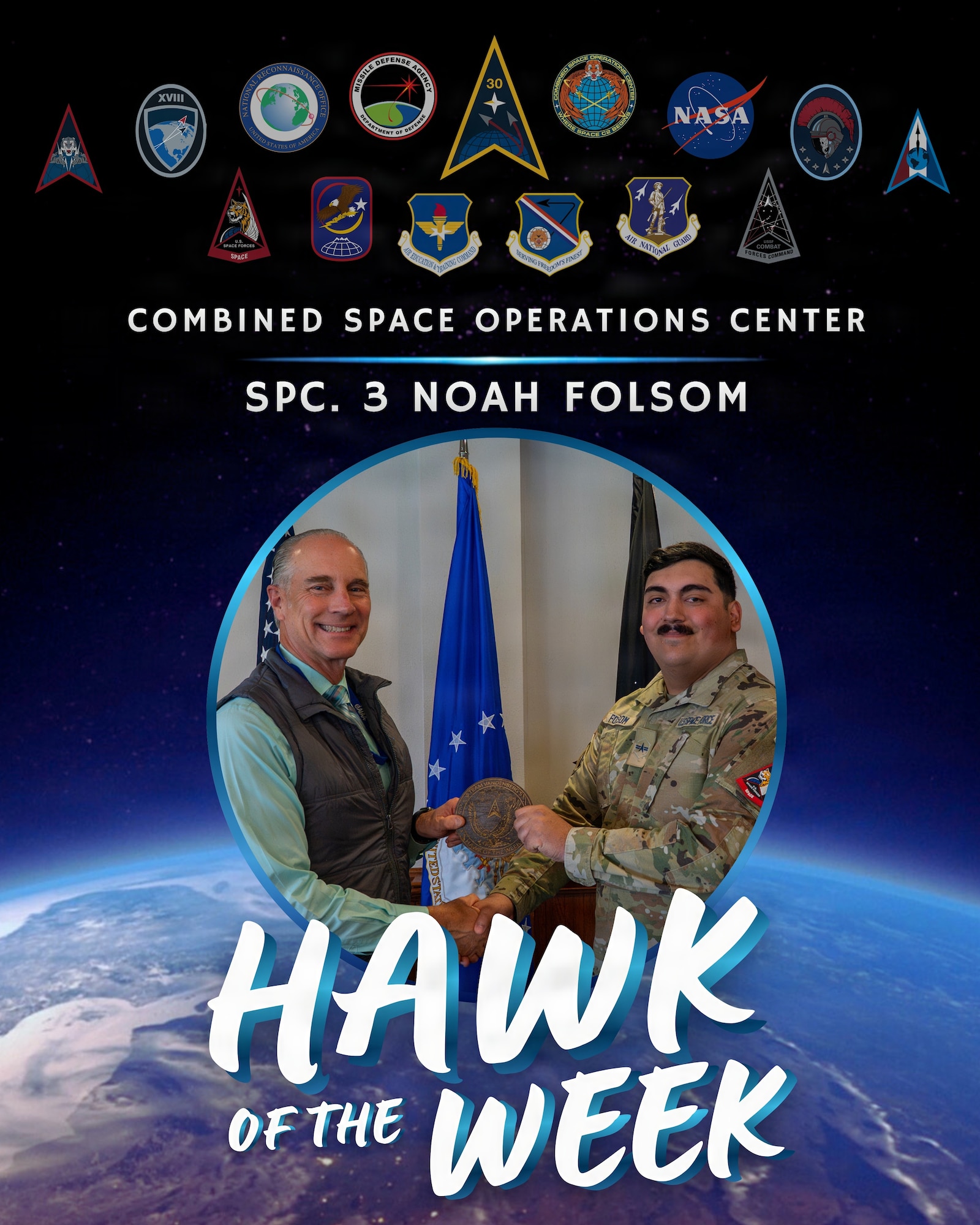 Two people stand side by side holding an award.