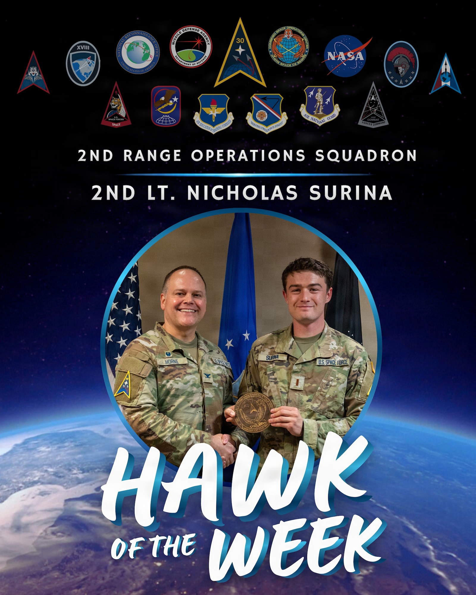 Two people stand side by side holding an award.