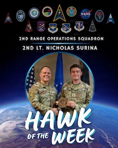 Two people stand side by side holding an award.