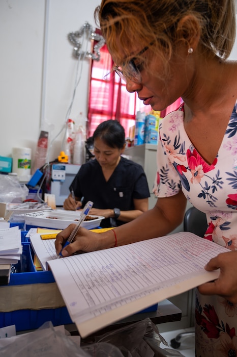 Feleina Davidson, Guyanan pharmacist, front, updates pharmaceutical records alongside U.S. Air Force Lt. Col. Hiep Tran, 349th Medical Squadron pharmacist, inside the outpatient pharmacy at the West Demerara Regional Medical Center in Vreed en Hoop, Guyana, March 19, 2026. U.S. Air Force medical personnel conducted pharmacy support operations during LAMAT 2026, ensuring continuity of care through accurate medication management while reinforcing readiness and enduring partnerships in the region. (U.S. Air Force photo by Maj. Stephani Schafer)
