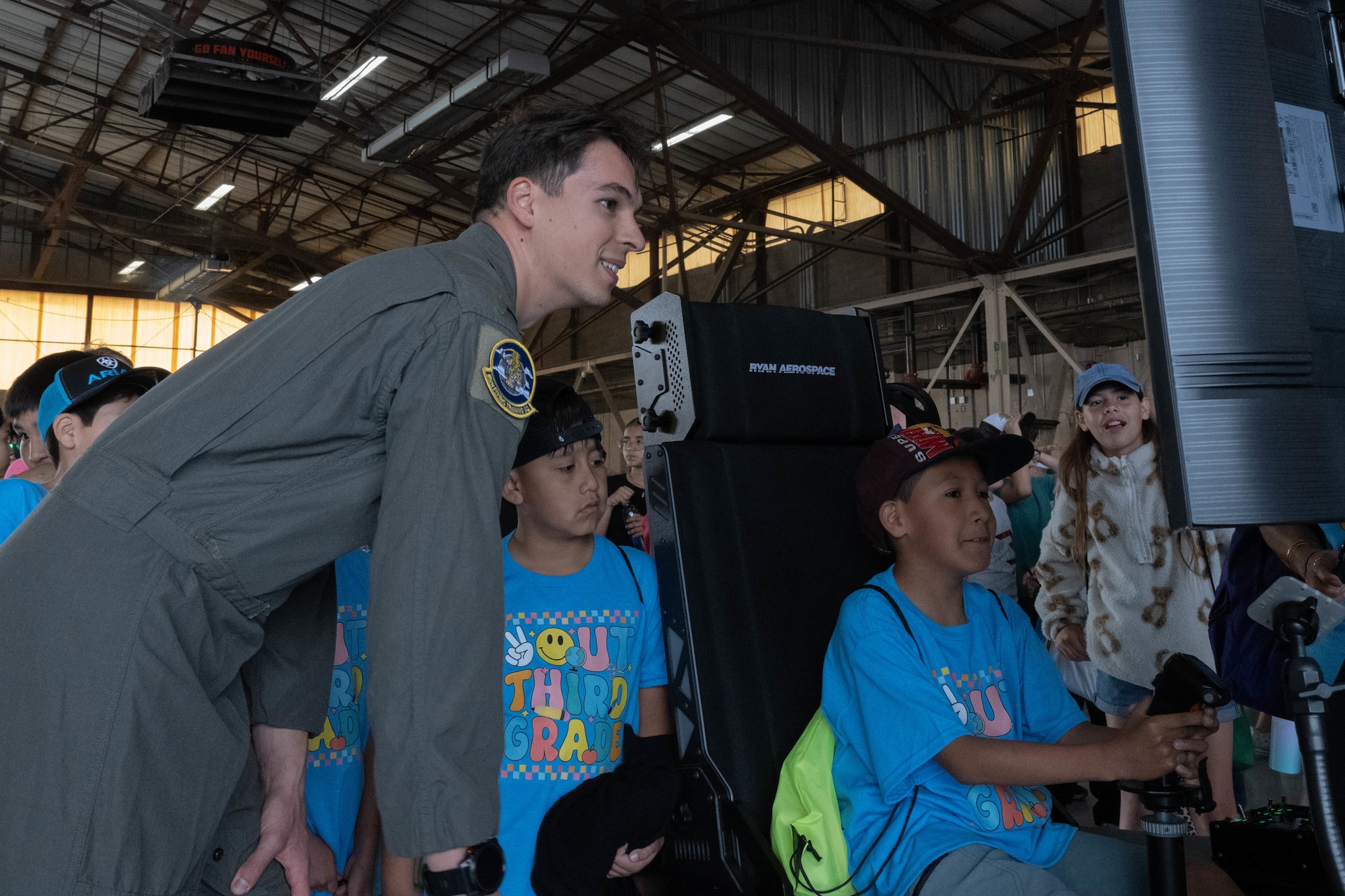 A U.S. Air Force Airman assigned to the 85th Flying Training Squadron observes a Fiesta of Flight STEM Expo guest pilot a flight simulator at Laughlin Air Force Base, Texas, March 27, 2026. Guests were given the opportunity to learn about Laughlin’s primary mission of producing mission-ready, world-class aviators. (U.S. Air Force photo by Airman 1st Class Darryl Keith)