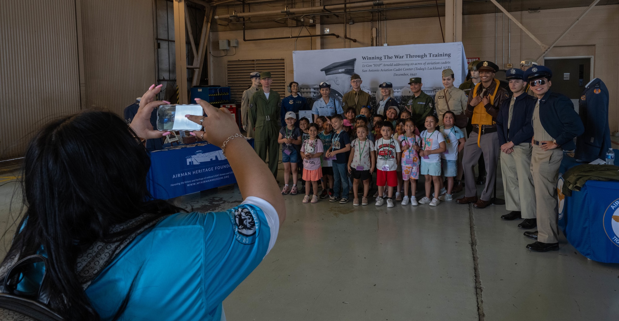 A teacher takes a photo of students alongside the U.S. Air Force Heritage Museum during the Fiesta of Flight STEM Expo at Laughlin Air Force Base, Texas, March 27, 2026. The USAF Heritage Museum educated guests about the Air Force’s history through a Living History exhibit. (U.S. Air Force photo by Airman 1st Class Darryl Keith)