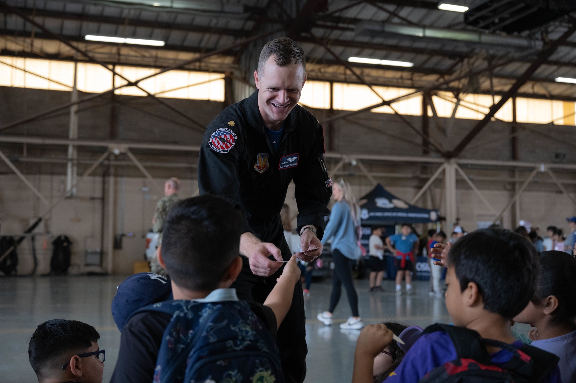 U.S. Air Force Maj. Sean Loughlin, F-35A Lightning II Demonstration Team pilot, hands out stickers to Fiesta of Flight STEM Expo guests at Laughlin Air Force Base, Texas, March 27, 2026. The F-35A Demonstration Team served as one of the exhibitors during the event. (U.S. Air Force photo by Airman 1st Class Darryl Keith)
