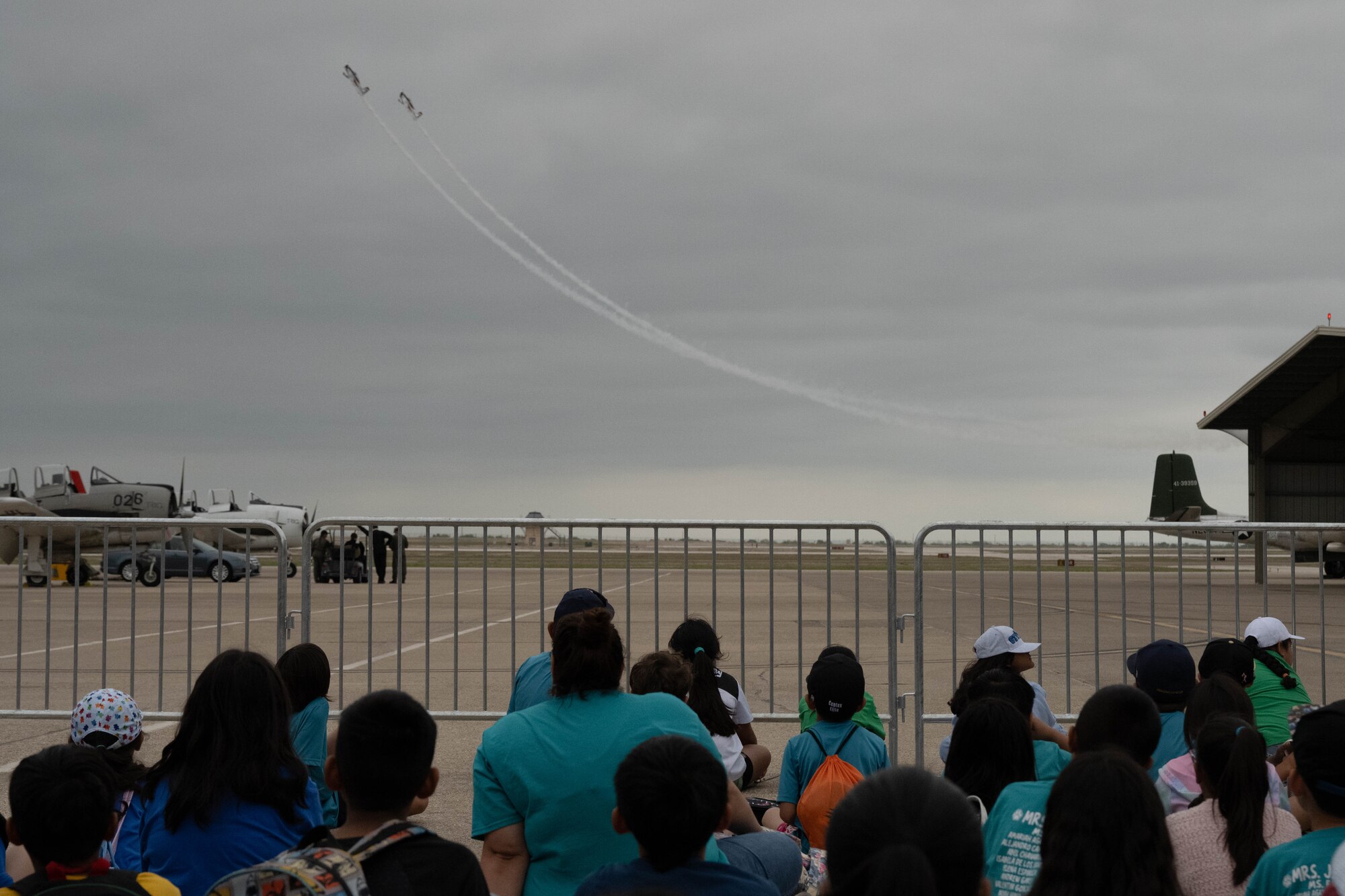 Teachers and students attending the Fiesta of Flight STEM Expo spectates the RedLine Airshows RV-8 aerobatic demonstration at Laughlin Air Force Base, Texas, March 27, 2026. Guests of the STEM Expo were able to see part of the Fiesta of Flight airshow rehearsal during outside exhibitions. (U.S. Air Force photo by Airman 1st Class Darryl Keith)