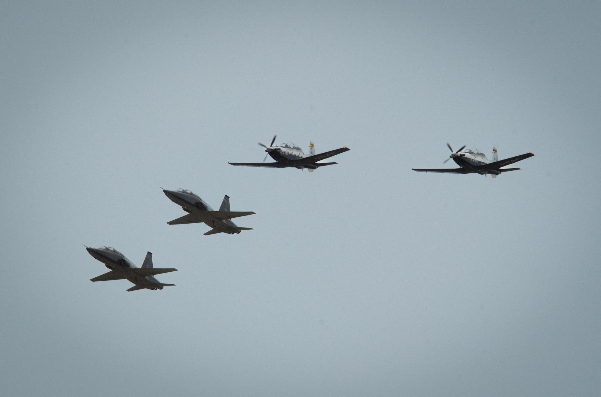 A four-ship formation of Laughlin’s T-38 Talons and T-6 Texan IIs flies during the Fiesta of Flight airshow at Laughlin Air Force Base, Texas, March 28, 2026. The aircraft represent key phases of undergraduate pilot training, from primary to advanced instruction. (U.S. Air Force photo by Airman 1st Class Harrison Sullivan)