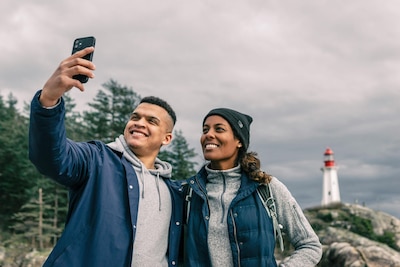 Man and woman take a selfie in front of a lighthouse