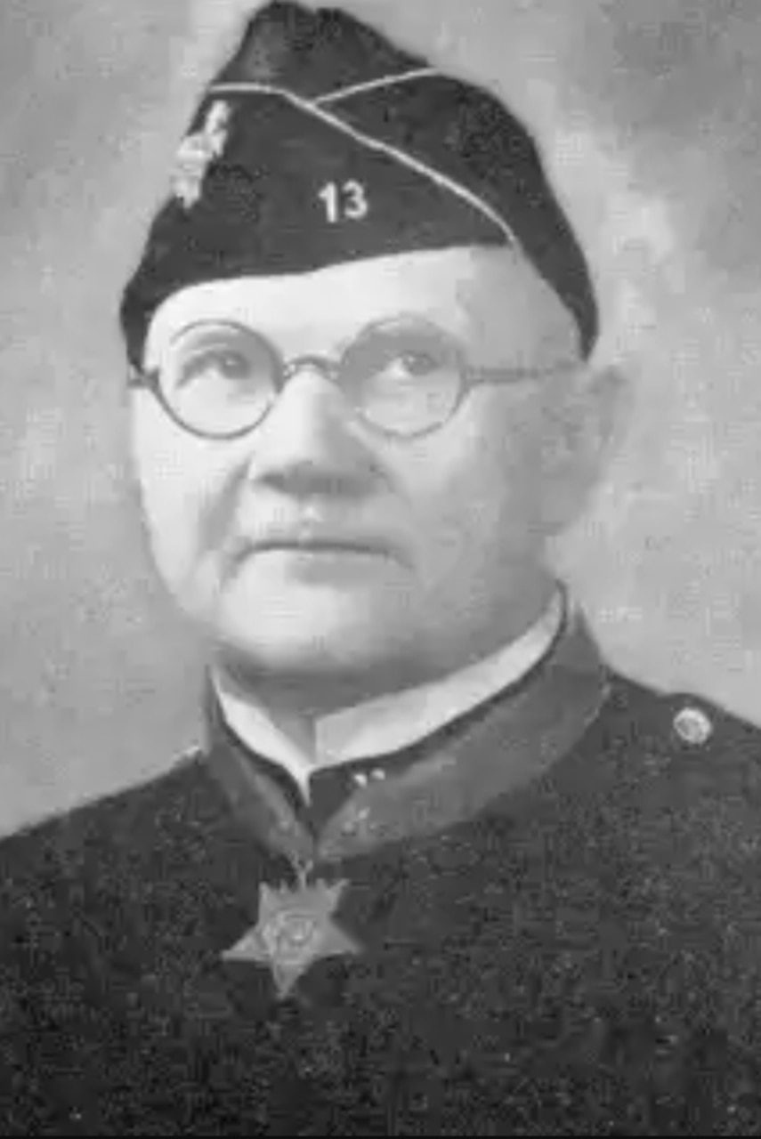 A man in a formal military uniform poses for a photo.