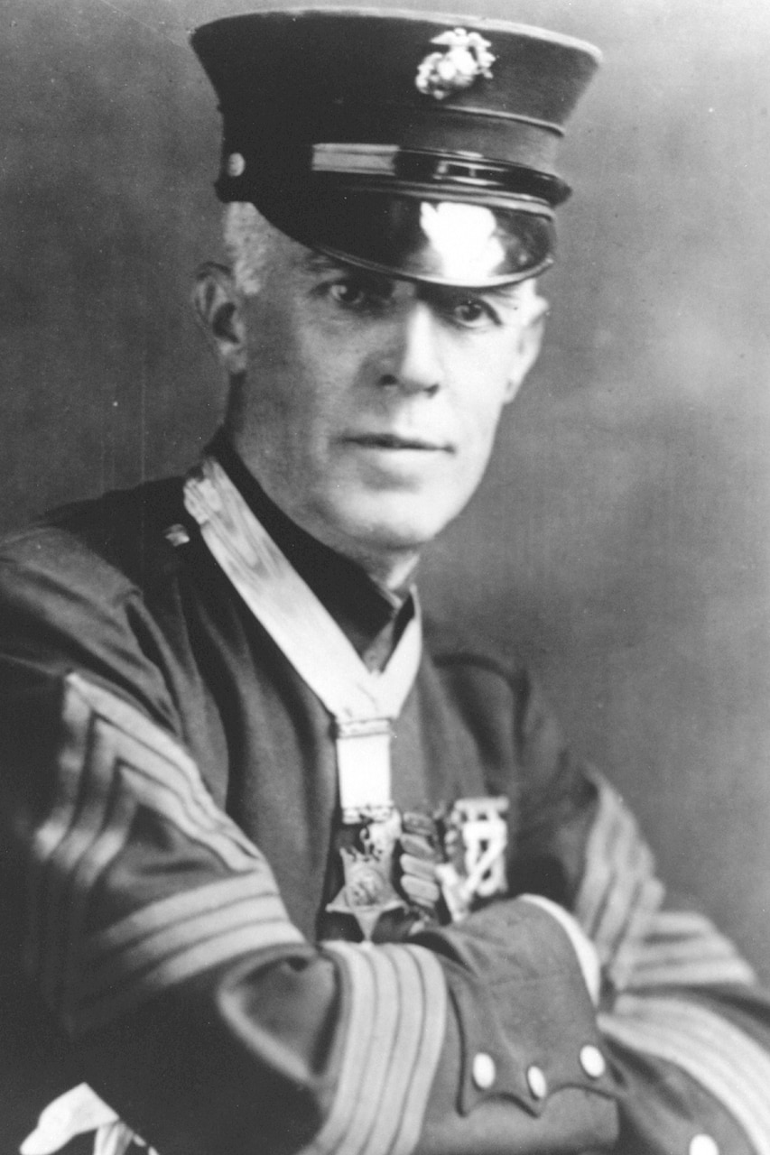 A man in a formal military uniform poses for a photo.