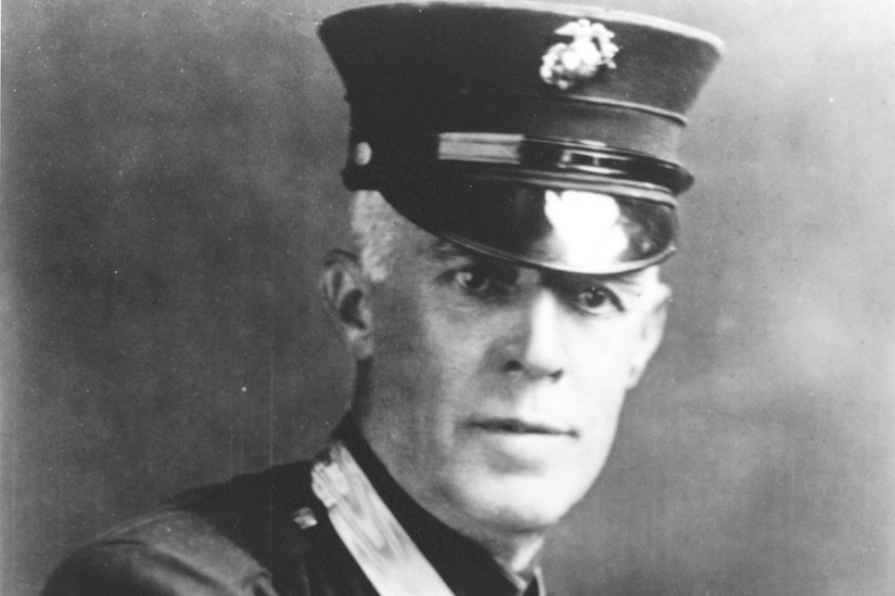 A man in a formal military uniform poses for a photo.