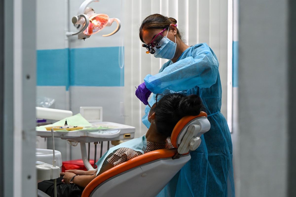 U.S. Air Force Reserve Lt. Col. Puneet Pande, 349th Medical Squadron dentist, performs a dental filling on a Guyanese patient at Cheddi Jagan Dental School in Georgetown, Guyana, March 18, 2026. During the Lesser Antilles Medical Assistance Team 2026 mission, Air Force dentists used restorative treatments like fillings to help preserve natural teeth to maintain long-term oral health. (U.S. Air Force photo by Staff Sgt. Dakota Carter)