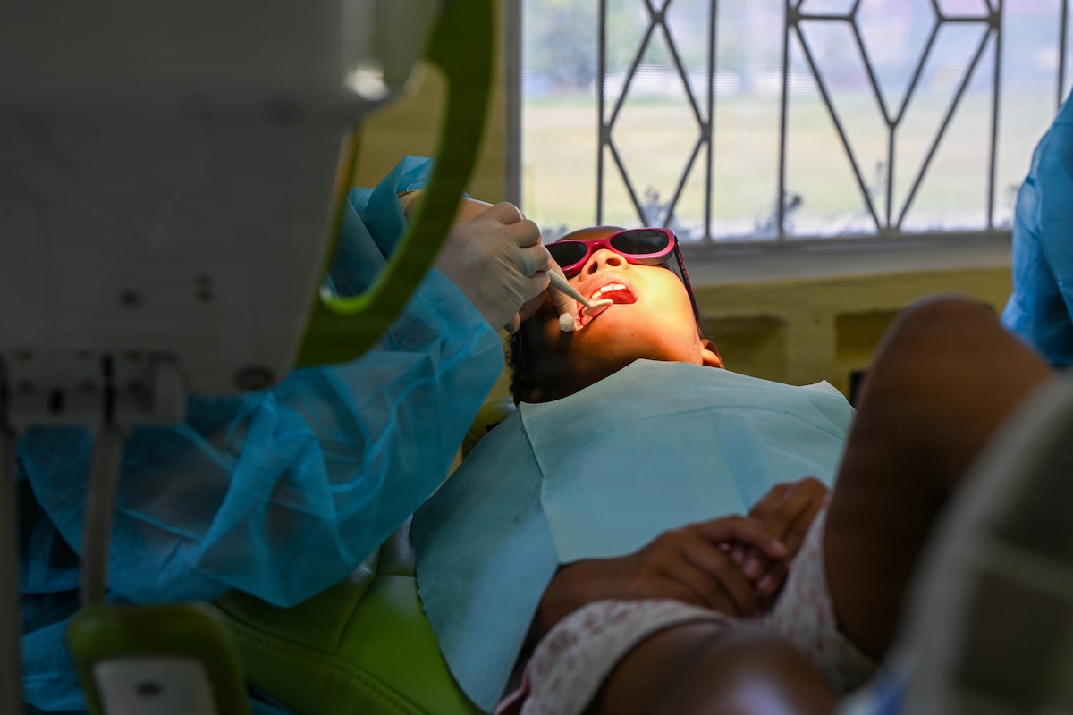 A U.S. Air Force Reserve dentist extracts a pediatric patient’s tooth at Cheddi Jagan Dental School in Georgetown, Guyana, March 18, 2026. During the Lesser Antilles Medical Assistance Team (LAMAT) 2026 mission, Air Force dental teams used extractions to address immediate dental concerns, while collaborating to share best practices and emphasize preventive care with their host nation counterparts. (U.S. Air Force photo by Staff Sgt. Dakota Carter)