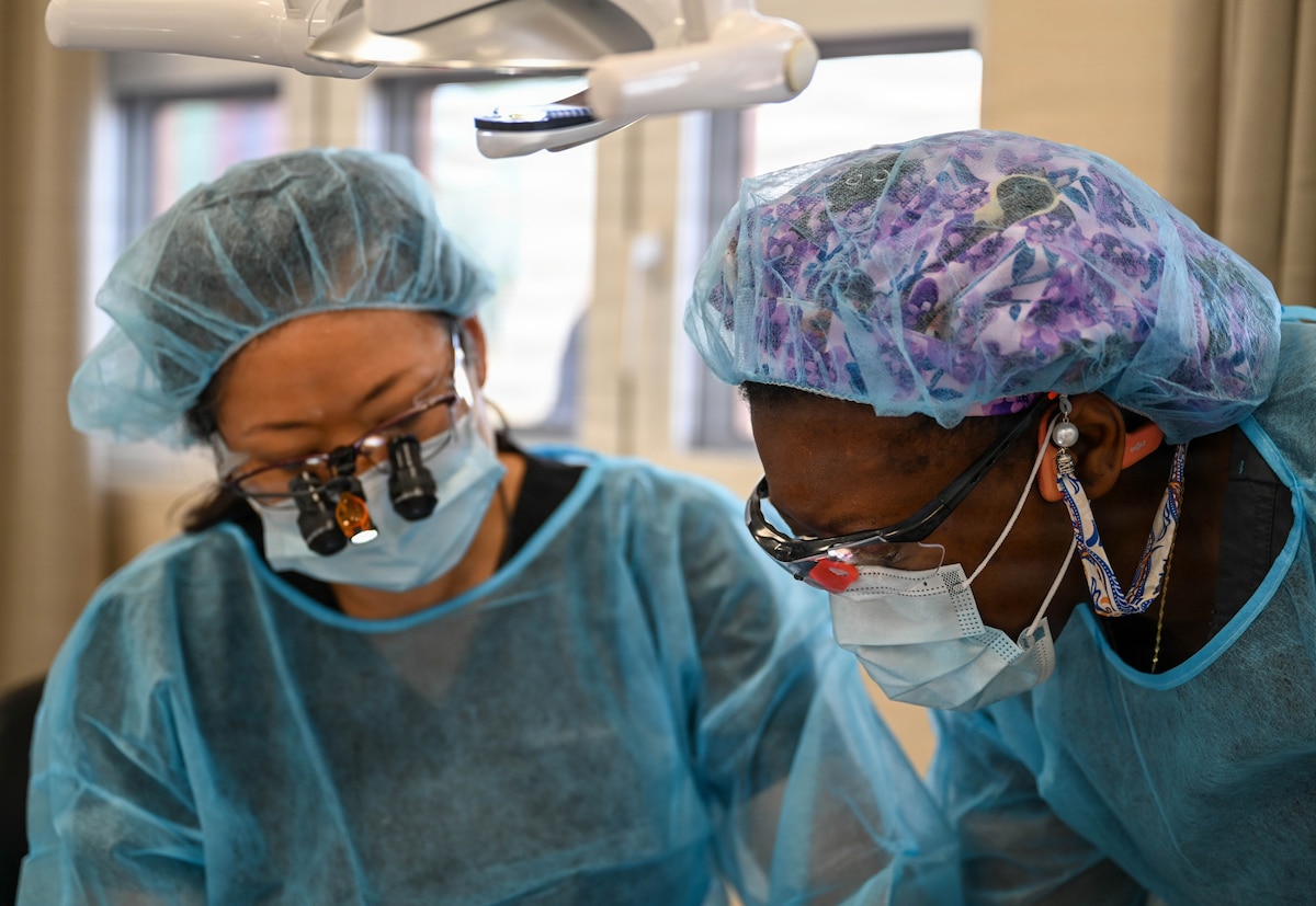 U.S. Air Force Tech. Sgt. Amanda Moss, 908th Aeromedical Staging Squadron flight chief, right, and Lt. Col. Eirleen Hyun, 349th Medical Squadron dentist,left, care for a Guyanese patient at De Kinderen Regional Hospital in West Coast Demerara, Guyana, March 17, 2026. During the Lesser Antilles Medical Assistance Team (LAMAT) 2026 mission, dental teams focused on preventive care, providing exams, cleanings, and guidance to help patients maintain long-term oral health. (U.S. Air Force photo by Staff Sgt. Dakota Carter)