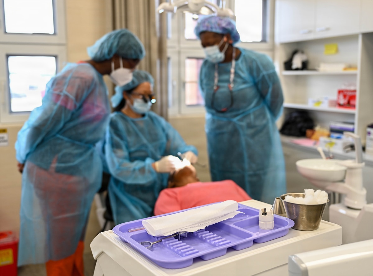 U.S. Air Force Lt. Col. Eirleen Hyun, 349th Medical Squadron dentist, center, and Tech. Sgt. Amanda Moss, 908th Aeromedical Staging Squadron flight chief, right, discuss dental procedural techniques with a Guyanese dentist at De Kinderen Regional Hospital in West Coast Demerara, Guyana, March 17, 2026. This collaboration, part of the Lesser Antilles Medical Assistance Team (LAMAT) 2026 mission, encouraged the synchronization of clinical standards and the sharing of best practices between medical professionals. (U.S. Air Force photo by Staff Sgt. Dakota Carter)