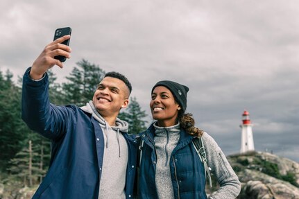 Man and woman take a selfie in front of a lighthouse