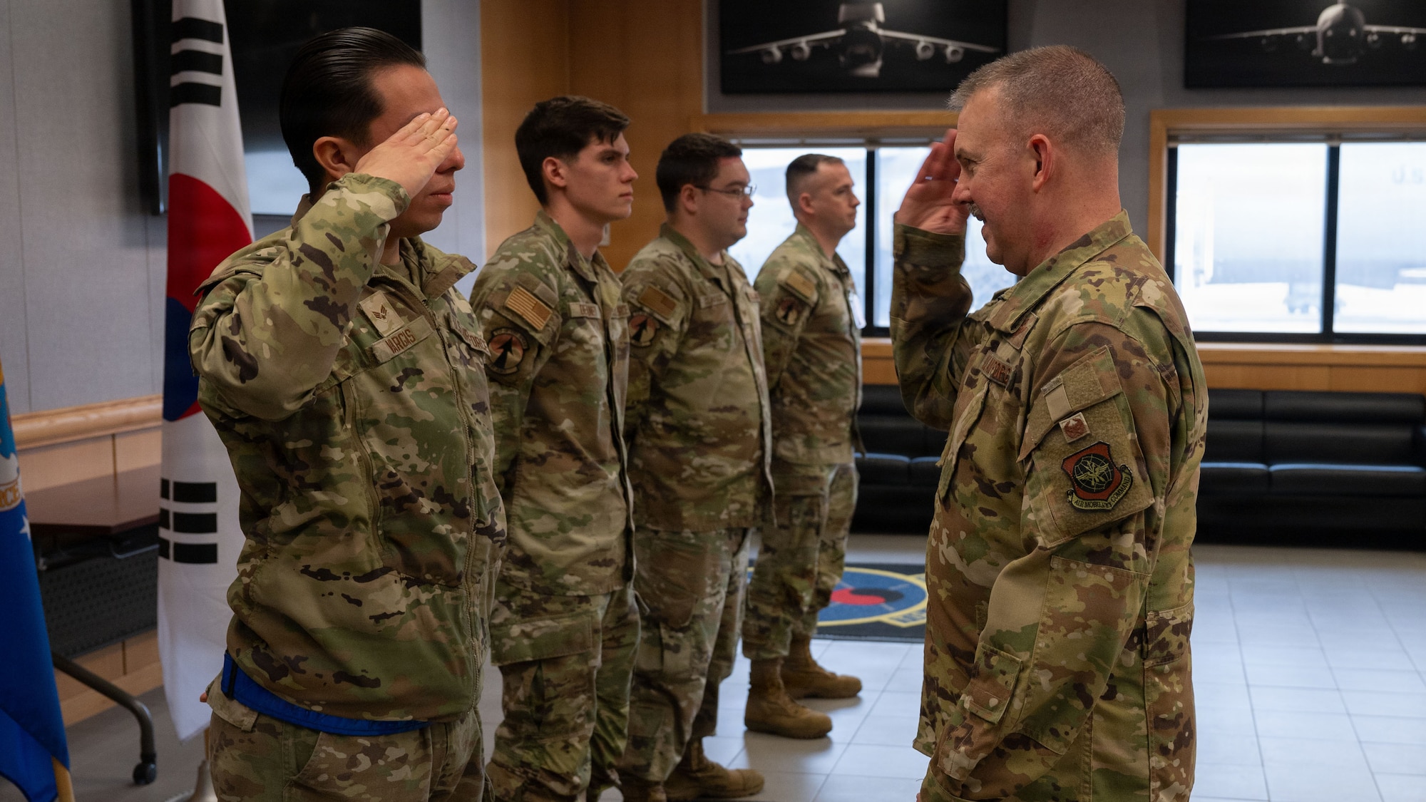 U.S. Senior Airman Jacob Vargas, left, 731st Air Mobility Squadron air freight technician, renders a salute to Col. Patrick Winstead, Eighteenth Air Force deputy commander, during a coin ceremony at Osan Air Base, Republic of Korea, April 1, 2026. During the visit, Col. Winstead met with Airmen across multiple units to better understand their roles in sustaining combat airpower and mission readiness. (U.S. Air Force photo by Senior Airman Rome Bowermaster)