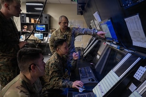Service members work together during an air traffic controller exchange program training.