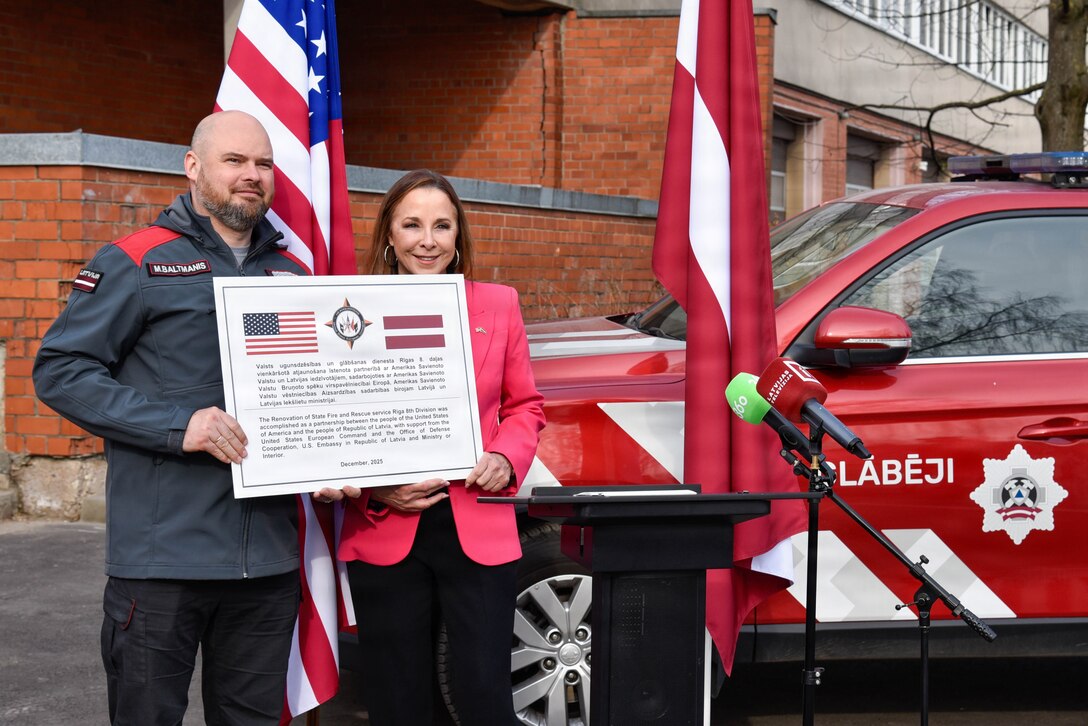 two people holding up a large plaque