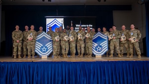 The newest senior master sergeant selects pose for a group photo during the Senior Master Sergeant Release party at Osan Air Base, Republic of Korea, April 2, 2026. The event recognized their dedication, leadership, and readiness to take on greater responsibilities. (U.S. Air Force photo by Staff Sgt. Sarah Williams)