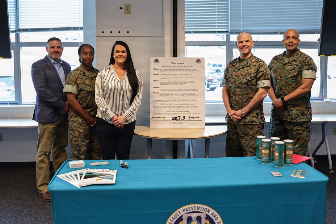 Marine Corps Recruiting Command leadership stand with the Sexual Assault and Prevention and Response coordinators after the signing of the MCRC SAPR Proclamation at Marine Corps Base Quantico, Va., March 31, 2026. The proclamation states that this April will be Sexual Assault Awareness and Prevention Month, and the meeting highlighted this year’s theme of “STEP FORWARD. Prevent. Report. Advocate.” (U.S. Marine Corps photo by Cpl. Brenna Ritchie)