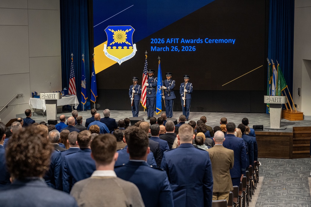 Students from the Air Force Institute of Technology’s Graduate School of Engineering and Management stand for the presentation of the colors at Wright-Patterson Air Force Base, Ohio, March 26, 2026.  The graduating class included 181 students along with international partners from Australia, Saudi Arabia, Chile, Brazil and Israel. (U.S. Air Force photo by Jack Gardner)