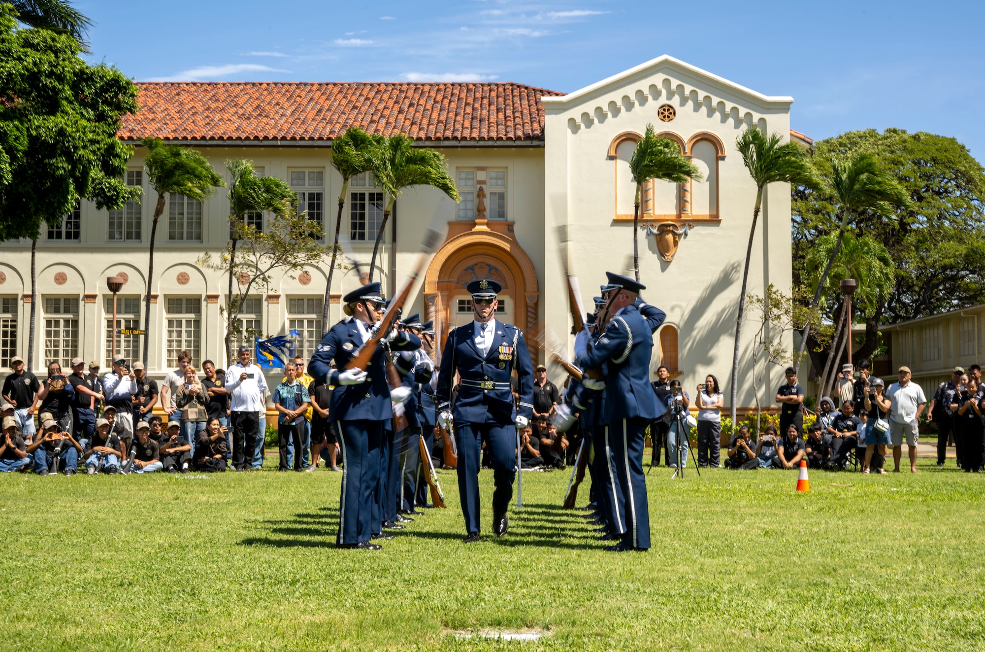 U.S. Air Force Capt. Andrew Paquin, center, officer in charge of operations with the U.S. Air Force Honor Guard, marches through spinning weapons during a drill team performance in Honolulu, March 28, 2026. The drill team performed at a Junior ROTC drill competition at President William McKinley High School as the headline event prior to the JROTC awards ceremony. (U.S. Air Force photo by Staff Sgt. Jordan Powell)