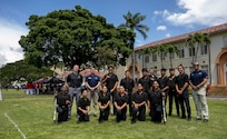 U.S. Air Force Honor Guard members and Konawaena High School Junior ROTC cadets gather for a photo in Honolulu, March 28, 2026. The Air Force ceremonial guardsmen served as judges during the Pacific Regional Drill Meet at President William McKinley High School, providing scores and feedback to participating high school JROTC cadets from across Hawaii. (U.S. Air Force photo by Staff Sgt. Jordan Powell)
