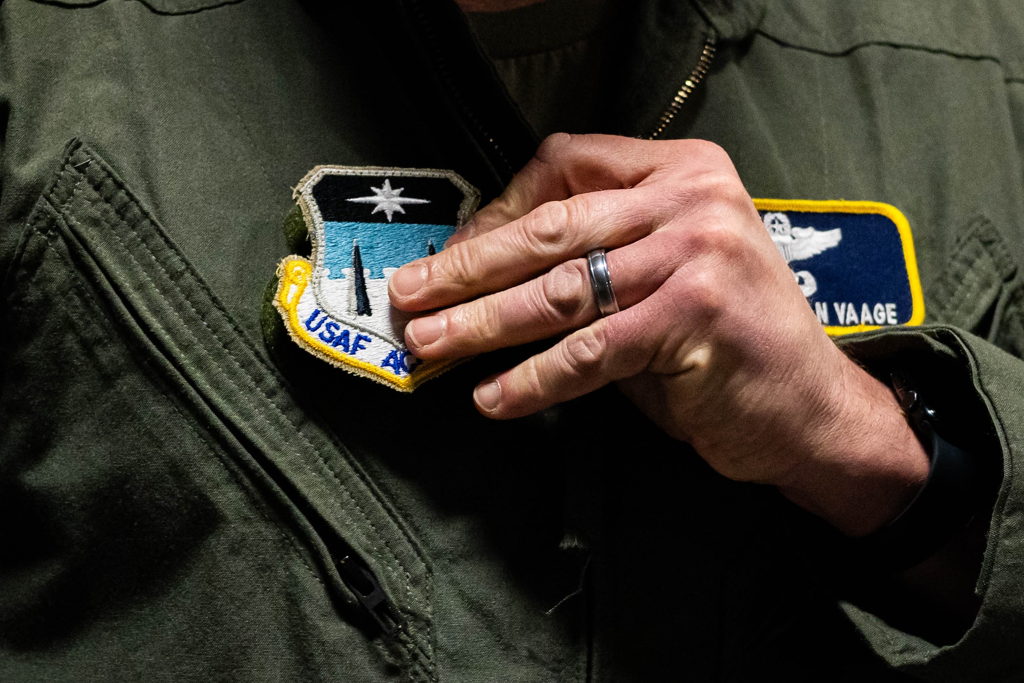 A close-up shot of an Air Force officer's hand grabbing his unit patch.