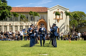 U.S. Air Force Capt. Andrew Paquin, center, officer in charge of operations with the U.S. Air Force Honor Guard, marches through spinning weapons during a drill team performance in Honolulu, March 28, 2026. The drill team performed at a Junior ROTC drill competition at President William McKinley High School as the headline event prior to the JROTC awards ceremony. (U.S. Air Force photo by Staff Sgt. Jordan Powell)